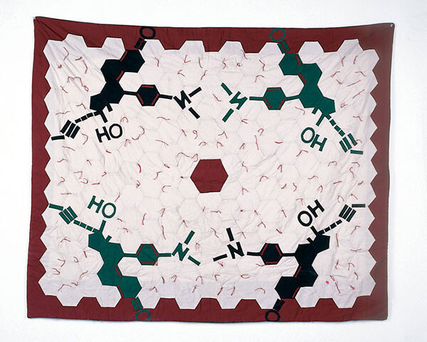 A red and white quilt with hexagonal panels